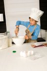 Мальчик делает торт — стоковое фото