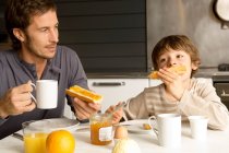 Взрослый мужчина завтракает со своим сыном — стоковое фото