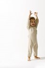 Bambino in piedi con le braccia alzate e sorridente — Foto stock
