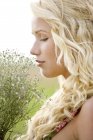 Портрет блондинки молодої жінки, що тримає купу квітів на відкритому повітрі — стокове фото