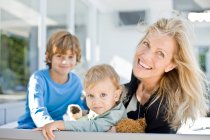 Retrato de una mujer sonriendo con sus dos hijos - foto de stock