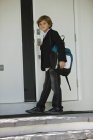 Retrato de estudante abrindo porta da escola — Fotografia de Stock