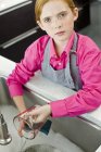 Close-up de gengibre menina lavar jarro de medição na pia — Fotografia de Stock