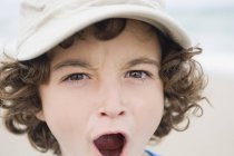 Portrait of boy in cap shouting and looking at camera — Stock Photo