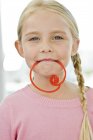 Retrato de menina segurando doces na boca — Fotografia de Stock