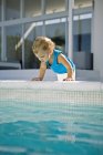 Cute baby boy looking into swimming pool — Stock Photo