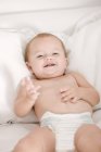 Gros plan de mignon bébé fille couché sur le lit et souriant — Photo de stock