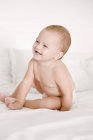 Gros plan de bébé fille riant sur le lit — Photo de stock