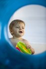 Bébé garçon jouant avec le jouet vu par l'anneau gonflable — Photo de stock