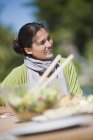 Улыбающаяся женщина обедает на свежем воздухе — стоковое фото