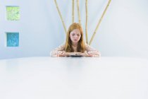 Сумна дівчина-імбир сидить за обіднім столом і дивиться на суші — стокове фото