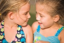 Дві дівчини дивляться один на одного і посміхаються — стокове фото