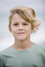 Portrait of blonde boy standing on beach — Stock Photo