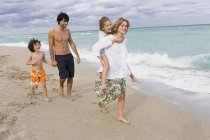 Família com crianças desfrutando de férias na praia de areia — Fotografia de Stock