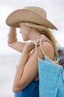 Donna in cappello borsa da trasporto sulla spiaggia — Foto stock
