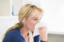 Close-up of woman blowing nose with handkerchief — Stock Photo