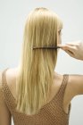 Visão traseira da mulher loira pentear o cabelo — Fotografia de Stock