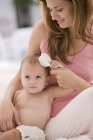 Mujer cepillado bebé hija cabello - foto de stock