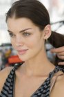 Mão de cabeleireiro que arranja o cabelo do modelo atraente — Fotografia de Stock