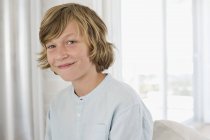 Ritratto di ragazzo adolescente biondo sorridente a casa — Foto stock