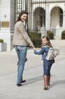Smiling girl with mother walking to school — Stock Photo