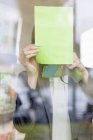 Empresária colando notas de memorando em vidro no escritório — Fotografia de Stock