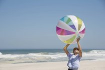 Дівчина грає на пляжі з барвистим м'ячем — стокове фото