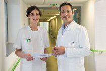 Médico e enfermeira sorrindo no corredor do hospital — Fotografia de Stock