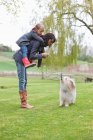 Donna che porta sua figlia a cavalluccio e rimprovera il suo cane — Foto stock