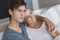 Happy young couple relaxing on bed in morning — Stock Photo