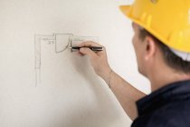 Мужчина-инженер в желтом шлеме работает на стройке — стоковое фото