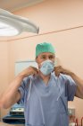 Чоловічий хірург носіння хірургічної маски в операційній кімнаті — стокове фото