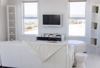Інтер'єр сучасної білої вітальні з затишним диваном — стокове фото