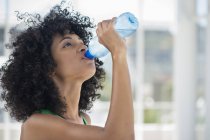 Primer plano de la mujer bebiendo agua de la botella - foto de stock