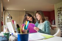 Girl studying with her mother at home — Stock Photo