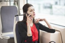 Женщина, путешествующая на автобусе и разговаривающая по мобильному телефону — стоковое фото