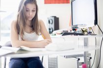 Задумчивая девочка-подросток учится дома — стоковое фото