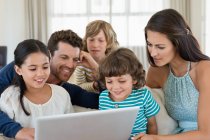 Famille regardant un ordinateur portable — Photo de stock