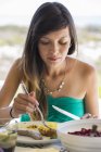 Mujer joven almorzando con salchichas al aire libre - foto de stock