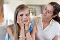 Woman persuading her upset daughter at home — Stock Photo