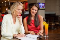 Дві жінки-друзі дивляться меню в ресторані — стокове фото