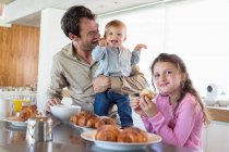 Famiglia che fa colazione al bancone di una cucina — Foto stock