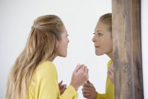 Elegante Frau begutachtet Make-up im Spiegel — Stockfoto