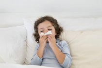 Cute little boy suffering from cold in bed — Stock Photo
