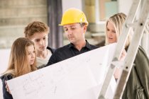 Engineer showing blueprint to family — Stock Photo