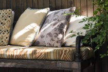 Close-up de sofá com travesseiros coloridos na luz solar — Fotografia de Stock