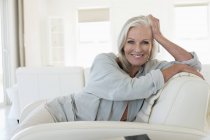 Porträt einer lächelnden Seniorin auf der Couch — Stockfoto