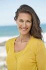 Retrato de mulher com cabelo castanho sorrindo na praia — Fotografia de Stock
