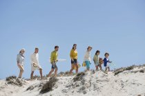 Familia feliz caminando en la playa de arena en verano - foto de stock