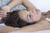 Close-up de mulher pensativa deitada na cama e pensando — Fotografia de Stock